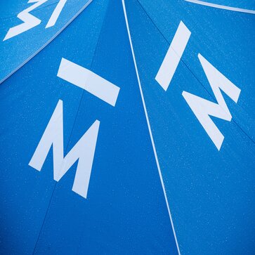 A close up shot of a steel blue canopy tent roof made from Pirontex fabric with water droplets.