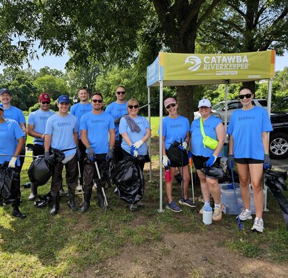 Participants of an outdoor cleanup stand underneath a 5x5 custom canopy tent. 