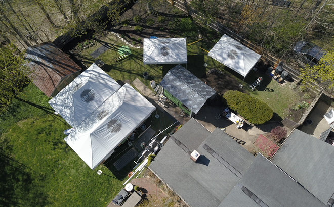 Bird's eye view of DeBlois Renovate and Remodel work site, with four Mastertent folding gazebos set up. 