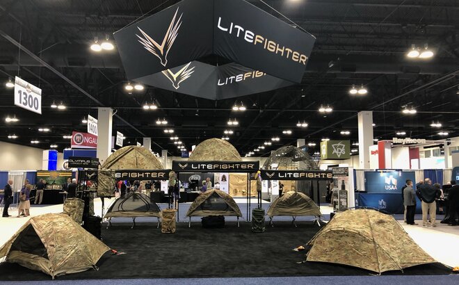 A retailer sells camping tents using a 10x10 custom canopy tent at a trade show. 
