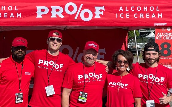 A company team in front of a printed red Mastertent Canopy tent.