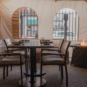 Mastertent ecru window sidewalls enclosing an outdoor dining space at Fig & Ash restaurant. 