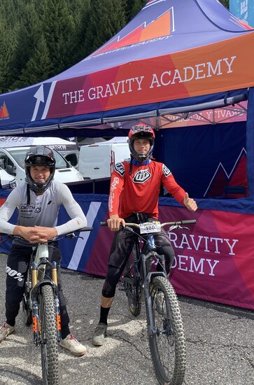 Two members of a mountain biking team standing with their bikes in front of a printed 17x17ft tent with custom printed walls. 
