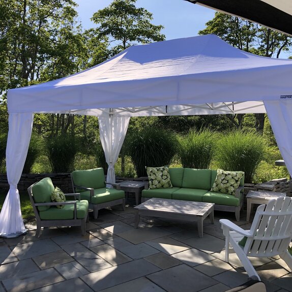 A 15x10 white canopy tent with a white frame creates shade above a backyard patio. 