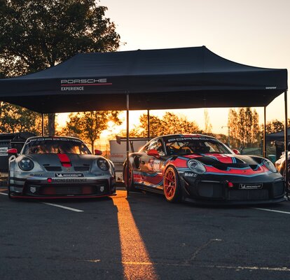 A black 20x10 canopy tent with custom printing and a black frame shades cars. 