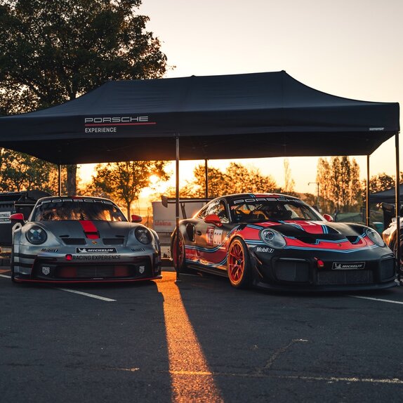 A black 20x10 canopy tent with custom printing and a black frame shades cars. 