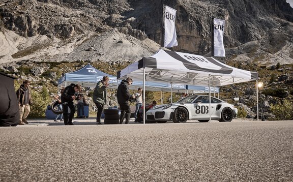 A black and white 20x10 canopy tent with custom printing shades cars.