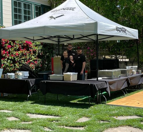 A 13x13 custom printed BBQ tent with a black tent frame and grey roof. 