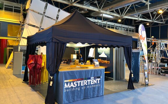 A 17x17 trade show tent indoors with canopy curtains and tent ceiling. 