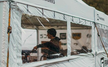 A 17x17 custom tent built for mountain biking with grey fabric, custom window fabrication, sidewalls and logo printing. 