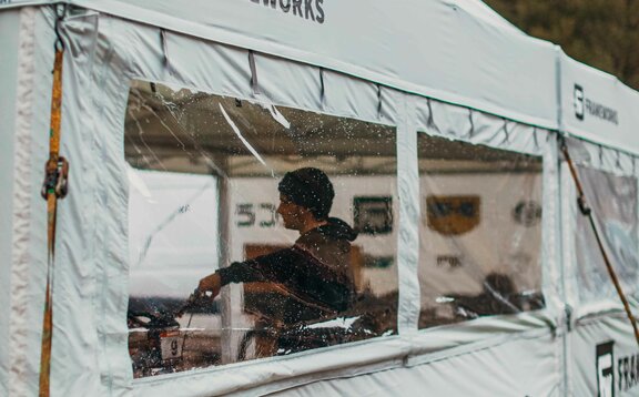 A 17x17 custom tent built for mountain biking with grey fabric, custom window fabrication, sidewalls and logo printing. 