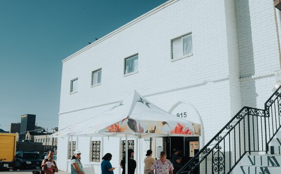 A group of women stand under a 10x10 nonprofit tent with custom printing and a tent awning. 