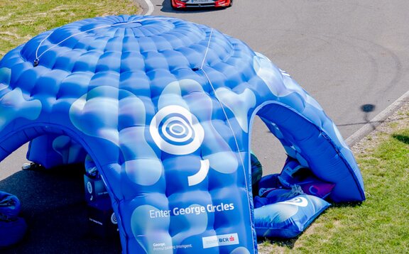 Large inflatable on a racetrack with car driving underneath. 