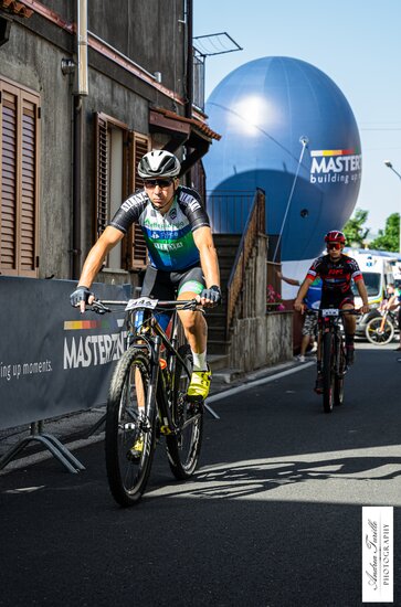 Cyclists racing in front of a Mastertent branded custom inflatable.  | © Andrea  Turillo Photography