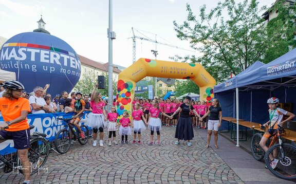 Participants stand under custom Mastertent Women's Run inflatable arch.  | © Helmut Moling Photography