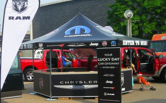 Mopar branded octagonal pavilion set up amidst trucks and flags. 