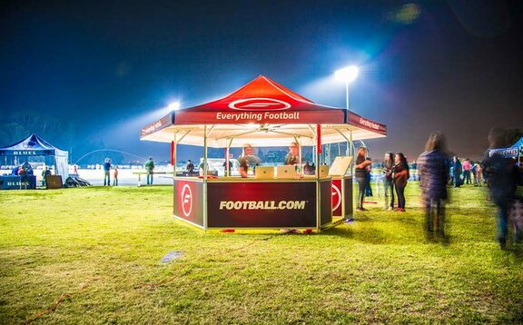 Football.com branded hexagonal pavilion set up on soccer field. 