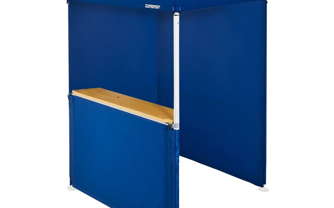 A blue 5x5ft Mastertent with three blue fabric sidewalls. Two sidewalls are closed and one is a half-height with a wooden counter. 