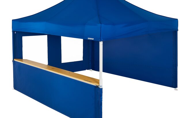 A blue 13x13ft Mastertent with three blue fabric sidewalls. One sidewall is closed, one is a window, and one is a half-height with a wooden counter. 