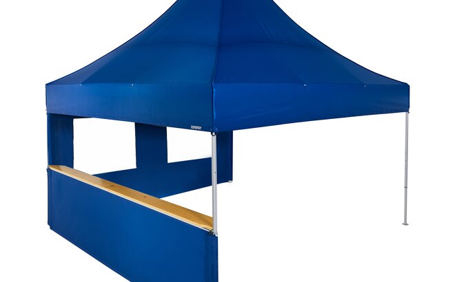 A blue 17x17ft Mastertent with two blue fabric sidewalls. One sidewall is window and one is a half-height with a wooden counter. 