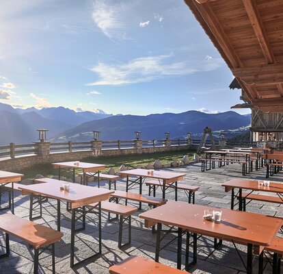 Mastertent beer table sets on an outdoor dining patio near a mountain range.