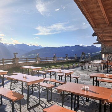 Mastertent beer table sets on an outdoor dining patio near a mountain range.