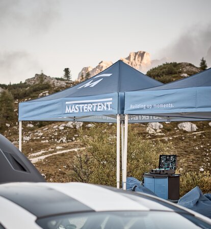 Mastertent 10x10ft Canopy Tents Blue printed canopy tents with Mastertent logos set up with mountains in the background.