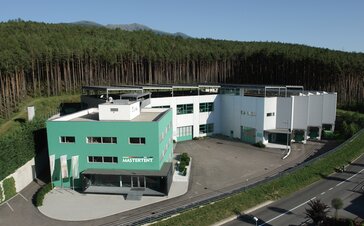 The Mastertent Building is green. In the background is a forest. 