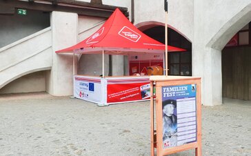 Il gazebo pieghevole promozionale completamente personalizzato Euregio Family Pass di fronte ad un muro.