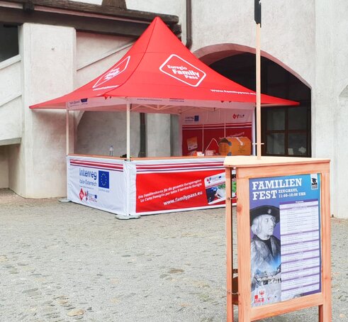 Il gazebo pieghevole promozionale completamente personalizzato Euregio Family Pass di fronte ad un muro.