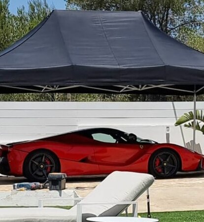 Black 4.5x3m Mastertent car gazebo with red Ferrari on luxury garden with pool