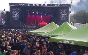 Bühne beim Alpen Flair Festival. In der Menschenmenge stehen die Pavillons von MASTERTENT.