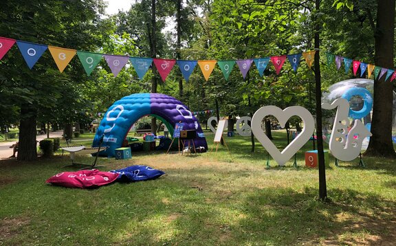 An inflatable tent is located at the Jazz in the Park Festival. It is colourful and big. It serves as a chill lounge and promotion corner. 