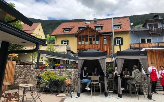 Due gazebo Loden di Mastertent sono situati sulla terrazza di un bistrò. Servono come tende per il catering. I clienti si godono le bevande sotto.  