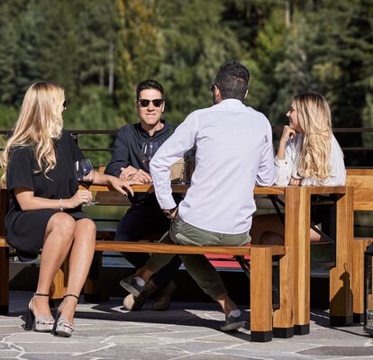 The special folding furniture "Lago" is placed at the terrace. There are four people sitting at the table.