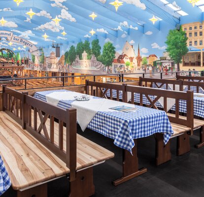 Custom-made sets for the Hacker Pschorr marqueee at the Oktoberfest. The tables have a blue and white checkered tablecoth. 