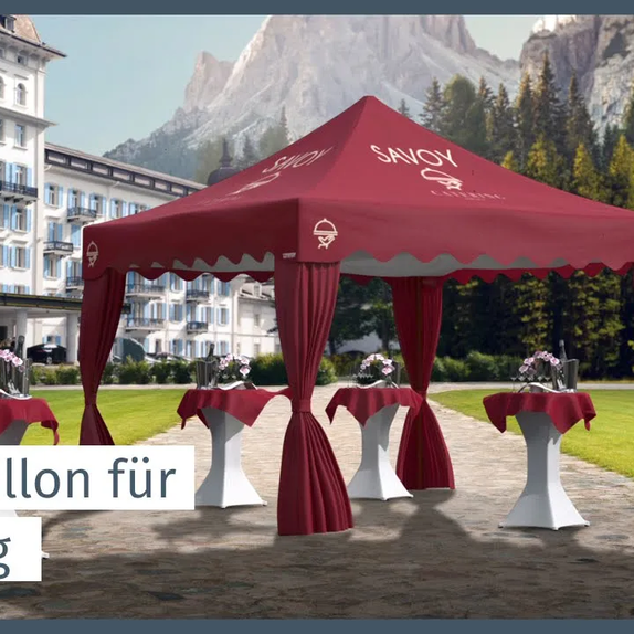 Roter eleganter Faltpavillon mit gewellter Blende und Eckvorhängen steht vor einem Hotel im Garten. Darunter befinden sich Stehtische.