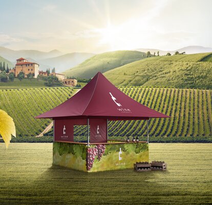 Gazebo pieghevole rosso con 4 tettoie automatiche si trova sul prato. Le pareti laterali sono stampate con le uve. Davanti il gazebo si trovano le bottiglie di vino.