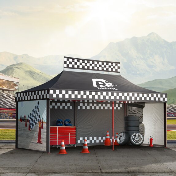 Black gazebo next to the race track. The gazebo is printed with racing patterns. Below them are tyres, cones and other motorsport accessories.