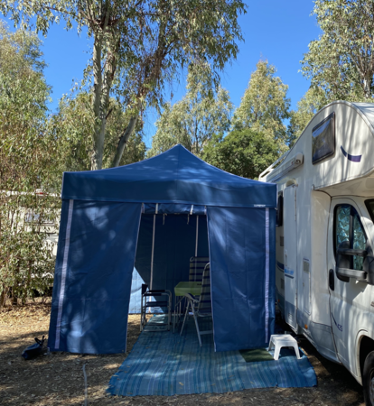 Gazebo da campeggio blu con pareti laterali blu serve come tenda da campeggio per roulotte.
