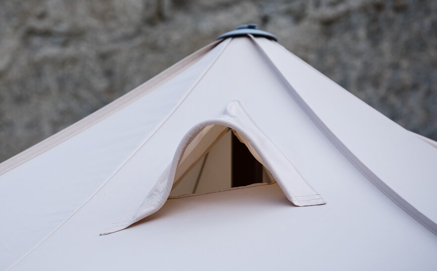 Ventilation system at the roof of a smoker's tent. It includes a net through which the smoke can exit easily. 