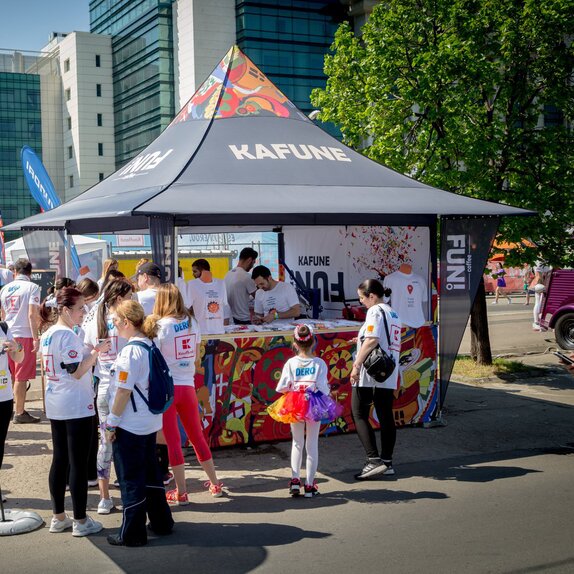 Bedruckter Faltpavillon mit Vordach bei einem Sportevent. Der Faltpavillon steht inmitten der Menschenmenge.