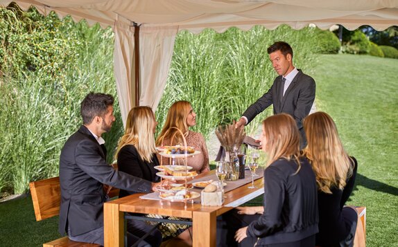 Die Menschen essen unter dem Zelt im Garten.