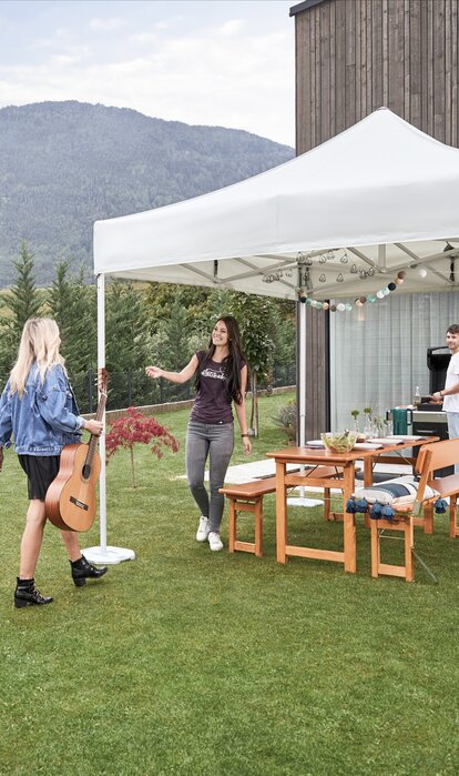 Gazebo pieghevole 3x3 m bianco per feste in giardino. Fissato al suolo con pesi in acciaio zincato ripara gli ospiti in caso di maltempo. 