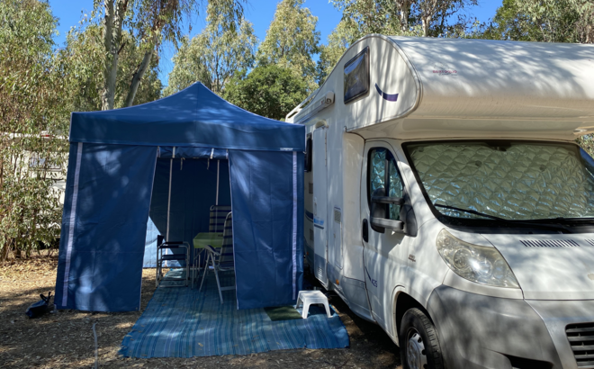 Gazebo da campeggio blu con pareti laterali blu serve come tenda da campeggio per roulotte.