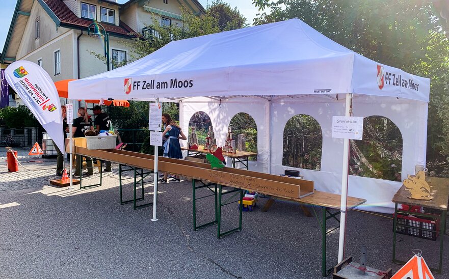 Weißes Faltzelt der FF Zell am Moos bei einem Feuerwehrfest.