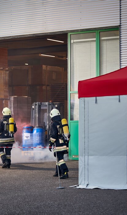 Il vigile del fuoco sta portando una vittima del incidente su una barella fuori dal capannone e la porta presso il gazebo pieghevole .