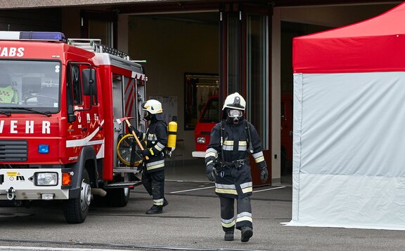 Fireman with breathing apparatus is walking between the car and the kit Rescue. 