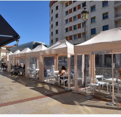 Elegante gazebo pieghevole 3x1,5 beige con struttura beige e pareti laterali in PVC trasparente per area esterna ristorante in una vietta 