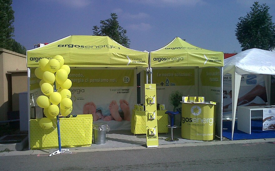 Gazebo pieghevole 3x1.5 lime con pareti laterali. Il gazebo è utilizzato per lo stand di una fiera ed è personalizzato con logo e grafiche Argosenergia